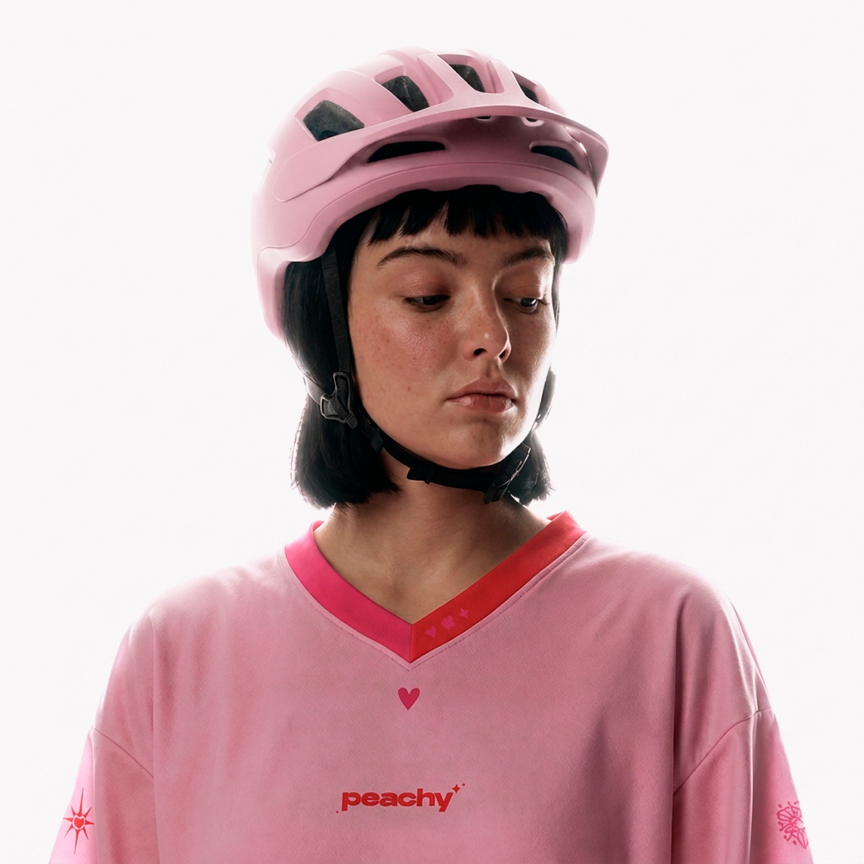 Cyclist wearing a pink Peachy jersey and helmet